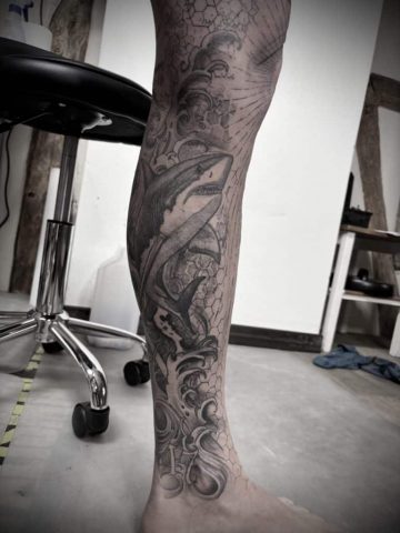 Großflächiges Black & Grey Bein Tattoo mit organischen Wellen- und Strukturmotiven am Unterschenkel, detailreiche Custom Tattooarbeit in Schwarz-Grau, gestochen von Sabine Jacobs im Talisman Tattoo Studio in Raeren – professionelles Tattoo Studio nahe Aachen, Eupen und Ostbelgien.