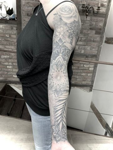 Floral Mandala Full Sleeve Tattoo im Black & Grey Stil mit Blumen, geometrischen Mandalas, Dotwork und ornamentalen Elementen, harmonisch gestaltetes Custom Tattoo über Schulter, Oberarm, Ellenbogen und Unterarm mit feiner Schattierung und klarer Linienführung, gestochen von Sabine Jacobs im Talisman Tattoo Studio in Raeren – exklusives Tattoo Studio nahe Aachen, Eupen, Ostbelgien und NRW.