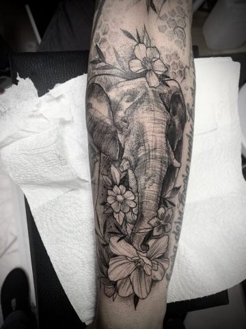 Detailreiches Elefant Tattoo am Unterarm im Black-and-Grey- und Dotwork-Stil, kombiniert mit floralen Elementen und feiner Schattierung, symbolisches Tier-Tattoo für Stärke, Schutz und Weisheit, individuelles Custom Tattoo gestochen von Sabine Jacobs im Talisman Tattoo Studio in Raeren – professionelles Tattoo Studio nahe Aachen, Eupen, Ostbelgien und NRW.