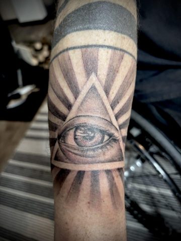 Custom Work Erinnerungs-Tattoo Auge des Sohnes in Black and Grey, realistisches Augen-Tattoo mit geometrischen Strahlen am Unterarm, emotionales Vater-Sohn Tattoo, individuelles Memorial Tattoo gestochen von Talisman Tattoo, Tattoo Studio Aachen Deutschland, Eupen Ostbelgien, NRW, Nähe Köln Düsseldorf Lüttich
