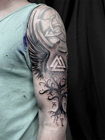 Nordisches Custom Tattoo mit Valknut Symbol, Lebensbaum und abstrakten Black & Grey Elementen, kraftvolles nordic Tattoo am Oberarm mit weichen Schattierungen und mystischer Symbolik, individuelles Viking Tattoo Design in modernem Blackwork Stil, handgezeichnetes Unikat von Sabine Jacobs im Talisman Tattoo Studio in Raeren – Premium Tattoo Studio für nordische Tattoos nahe Aachen, Eupen und Ostbelgien.