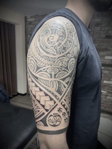 Polynesian Tribal Tattoo im Black & Grey Stil mit ornamentalem Pattern und geometrischen Elementen am Oberarm, kraftvolles Custom Tattoo mit klaren Linien, Flächenarbeit und traditionell inspirierten Motiven, professionell gestochen von Sabine Jacobs im Talisman Tattoo Studio in Raeren – exklusives Tattoo Studio nahe Aachen, Eupen, Ostbelgien und NRW.