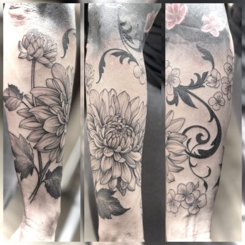 Florale Fine Line Blackwork Tattoos mit Blumenmotiven am Unterarm, detailreiche botanische Tattoo-Kunst in Schwarz-Grau, gestochen von Sabine Jacobs im Talisman Tattoo Studio in Raeren – hochwertige Custom Tattoos nahe Aachen, Eupen und Ostbelgien.