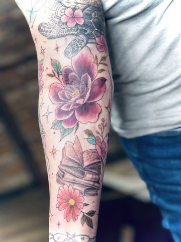 Phantasy Fabelwesen Tattoo in buntem Fineline-Stil am Arm, Buch, Blumen, Sterne detailreiche Fantasy-Komposition mit Blumen, Einhorn und weiblicher Figur, farbiges Custom Tattoo gestochen von Talisman Tattoo, Tattoo Studio nahe Aachen Deutschland, Eupen & Sankt Vith Ostbelgien, Luxemburg, NRW – individuelles Fantasy Tattoo, fein ausgearbeitet, künstlerisch, hochwertig und einzigartig