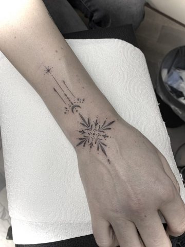 Fineline Tattoo mit Stern, Mond und ornamentalen Elementen, minimalistisches Linework Tattoo am Handgelenk und Unterarm, feines spirituelles Symbol Tattoo in Black, gestochen bei Talisman Tattoo – Sabine Jacobs, exklusives Tattoo Studio in Raeren, Belgien nahe Aachen, NRW, Eupen, Sankt Vith, Luxemburg, Europa, internationale Tattoo Kundschaft