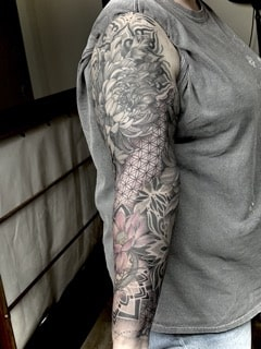 Japanischer Black-and-Grey Sleeve mit großer Chrysantheme, Lotusblüte, geometrischen Mustern,mandala,dotwork,pattern und ornamentalem Hintergrund am gesamten Arm.
