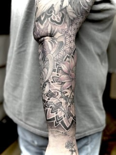 Japanischer Black-and-Grey Sleeve mit großer Chrysantheme, Lotusblüte, geometrischen Mustern,mandala,dotwork,pattern und ornamentalem Hintergrund am gesamten Arm.