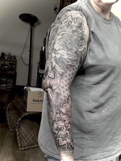 Japanischer Black-and-Grey Sleeve mit großer Chrysantheme, Lotusblüte, geometrischen Mustern,mandala,dotwork,pattern und ornamentalem Hintergrund am gesamten Arm.