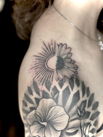 Black-and-Grey Fine-Line Schulter- und Oberarmtattoo mit floralen Elementen, Sonne und geometrischem Muster nach Cover-up und Touch-up, individuelles Custom Tattoo von Talisman Tattoo Sabine Jacobs in Raeren, nahe Aachen und Eupen.