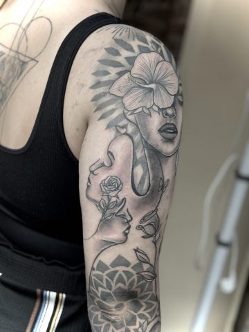 Nachher-Ergebnis eines großflächigen Black-and-Grey Oberarmtattoos mit weiblichem Porträt, floralen Elementen und geometrischem Muster nach Cover-up und Touch-up, individuelles Custom Tattoo von Talisman Tattoo Sabine Jacobs in Raeren, nahe Aachen und Eupen.