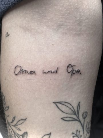 Schrift Tattoo „Oma und Opa“ in feiner Handschrift, emotionales Erinnerungs-Tattoo am Unterarm, minimalistisches Fineline Schrift Tattoo in Black, gestochen bei Talisman Tattoo – Sabine Jacobs, exklusives Tattoo Studio in Raeren, Belgien nahe Aachen, NRW, Eupen, Sankt Vith, Luxemburg, Europa, internationale Tattoo Kundschaft