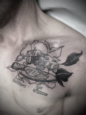 Vorher-Zustand eines Brust- und Schultertattoos mit floralen Elementen und Schrift vor geplantem Cover-up, Ausgangssituation für individuelles Custom Tattoo bei Talisman Tattoo Sabine Jacobs in Raeren, nahe Aachen und Eupen.
